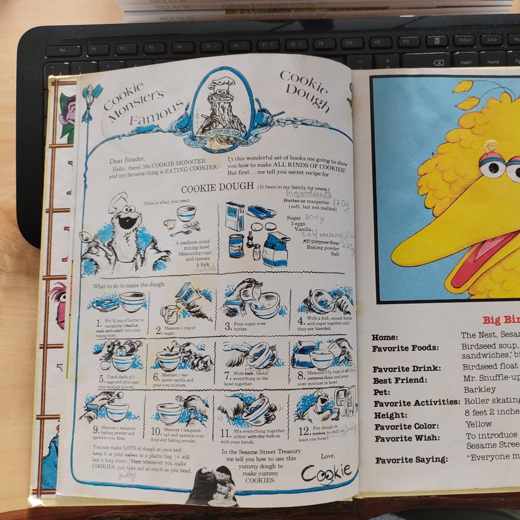 An open book, showing a page detailing a recipe for "Cookie Monster's Famous Cookie Dough".